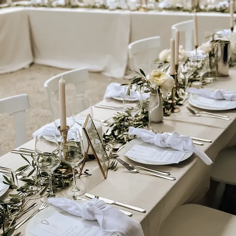 Eine Hochzeitstafel mit Dekorationen in weiß und hellgrün