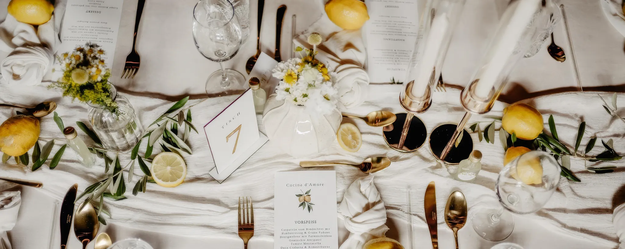 Eine Hochzeitstafel von oben betrachtet, mit Zitronen und Oliven dekoriert